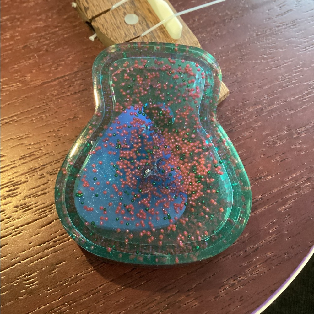 Handmade resin guitar pick case with pick.